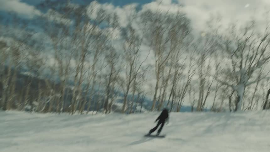 Person snowboarding down a snow slope on a mountain