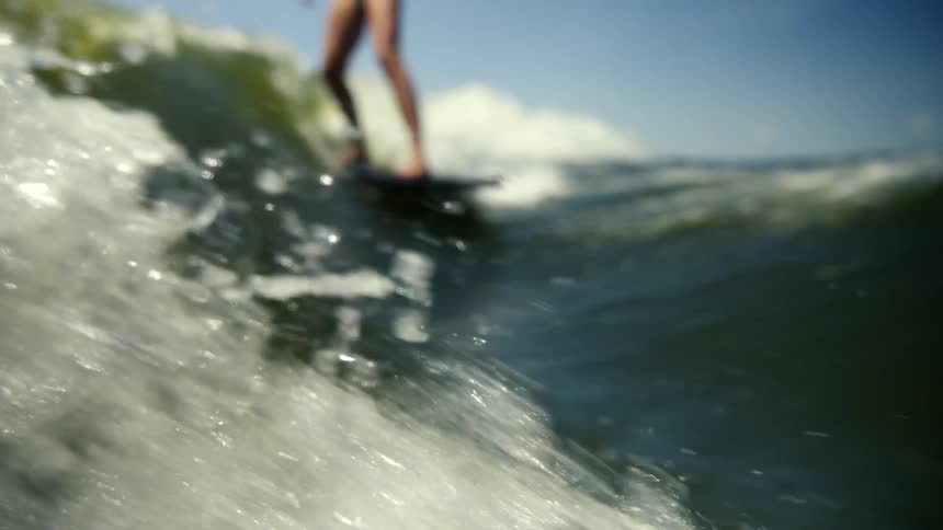 A woman is wakeboarding in the ocean