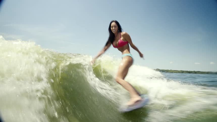Woman surfing a wave on a clear day