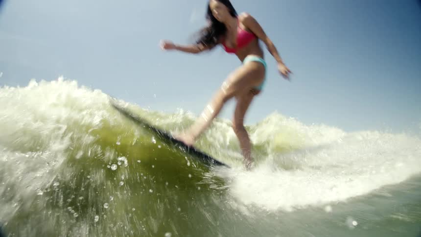 Woman showing off her skills while surfing a wave