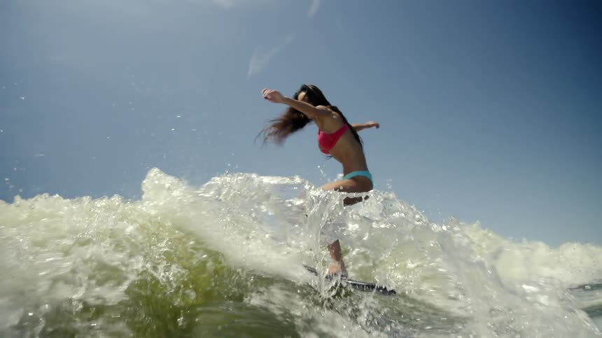A woman is surfing on the waves
