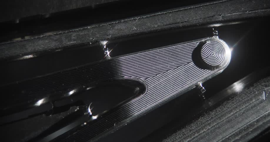 Zoom-in on a CNC machined mountain bike's piece as light reflects on the metal