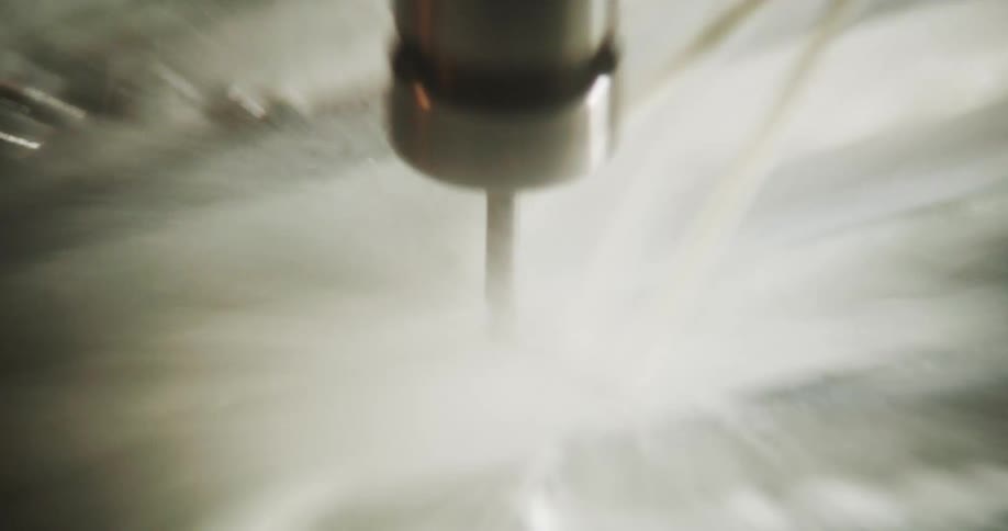 Zoom-in on a Cnc machine in operation with the drill cutting a metal material