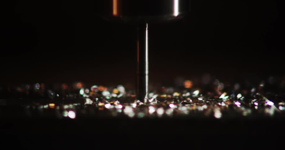 Closeup view of metal shavings scattered around a machining tool possibly a drill or lathe