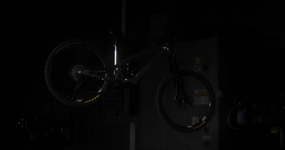 Bicycle hanging by a chain in machine shop