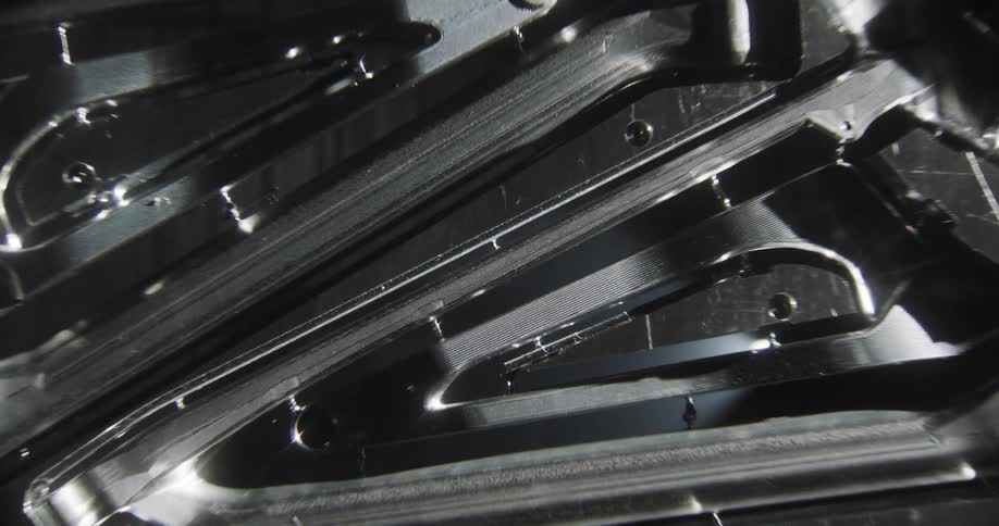 Zoom-in on a CNC machined bike frame with light reflects pouring through