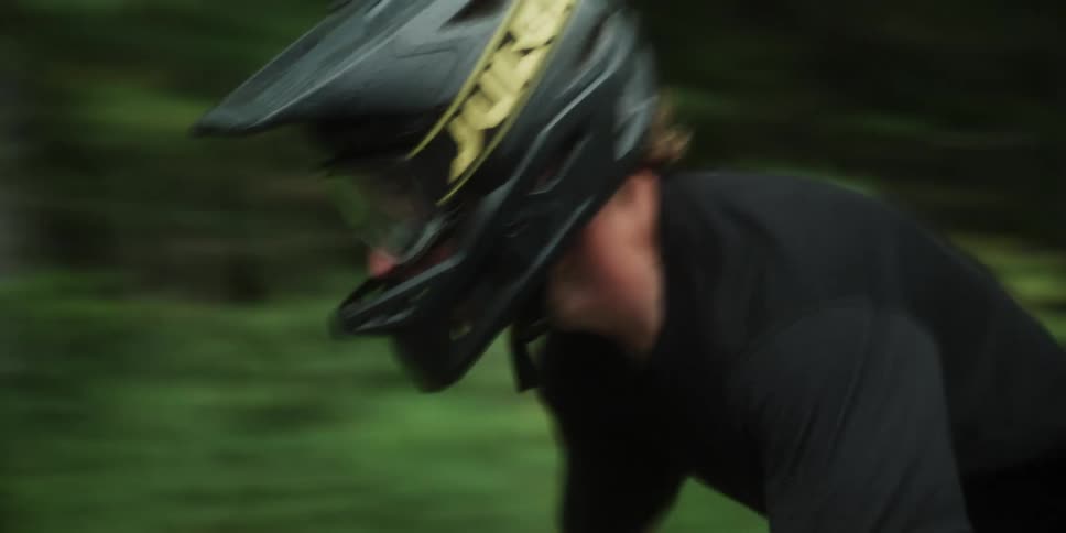 A man races through a forest on a bike