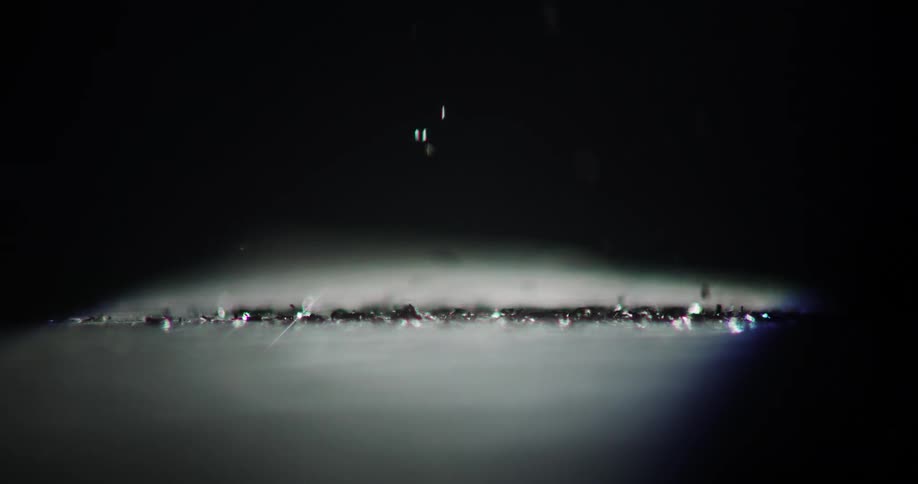 Metal shavings fall onto the ground