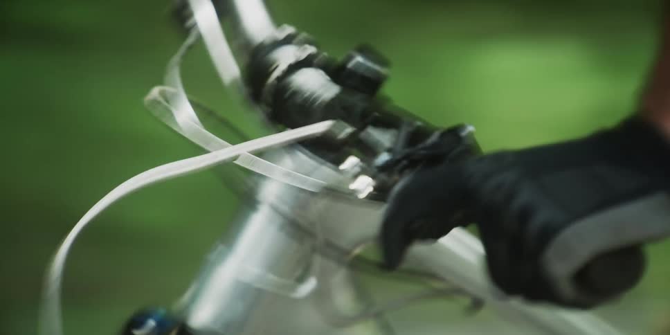 The arms of a person with black gloves riding a mountain bike downhill