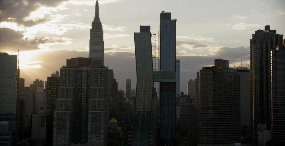 The sun is setting behind these tall buildings