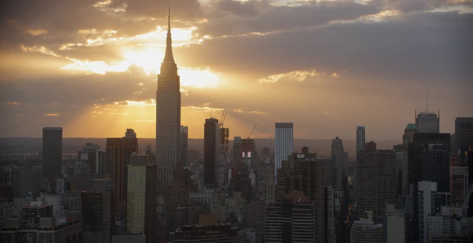 View of a large city with sun shining through clouds