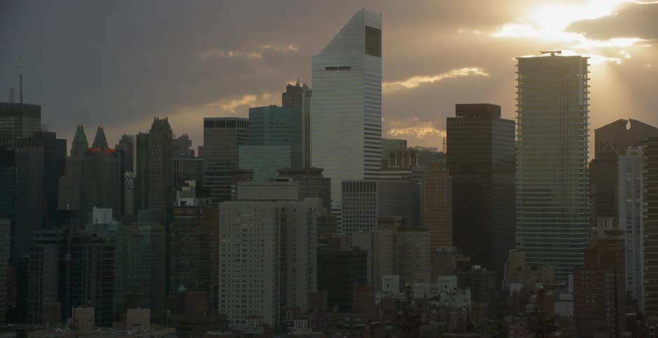View of a large city with sun shining through clouds