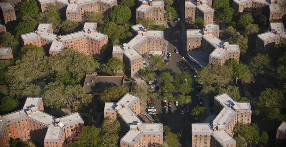 Large apartment buildings and traffic with many trees