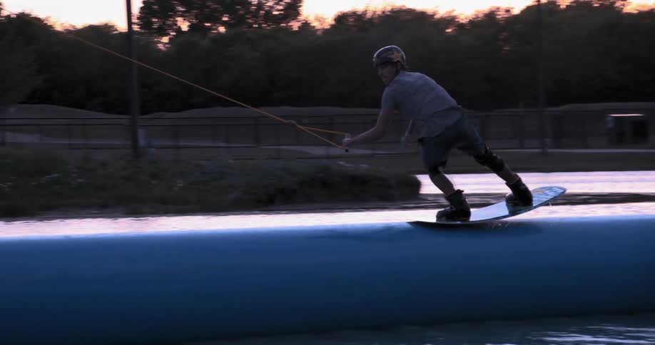 A wakeboarder jumps onto a floating platform