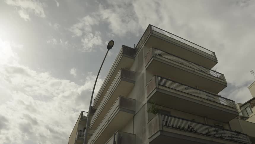 An apartment building with wide balconies in a city corner