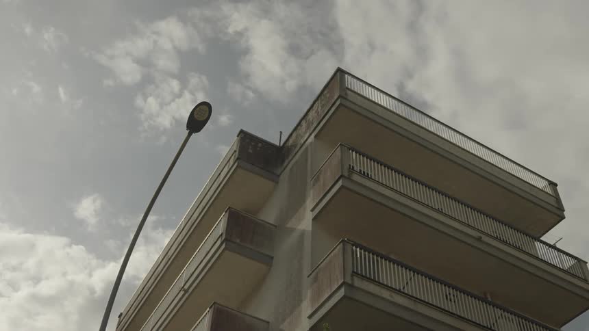 Apartment building with balconies against the cloudy sky