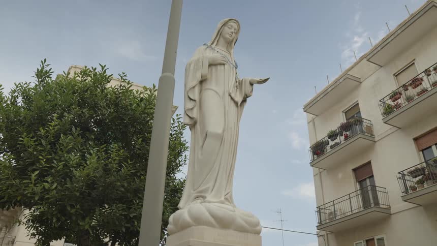 A statue of a woman is outside the apartment building