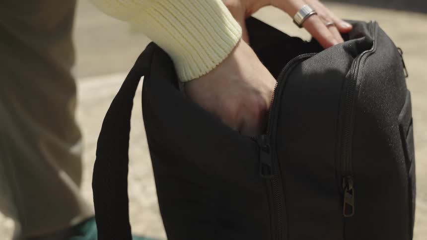Man taking spray paint from his backpack