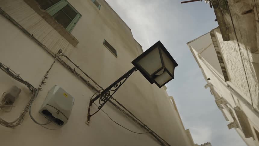 Classic lamppost on the wall of a building in the middle of a residential alley
