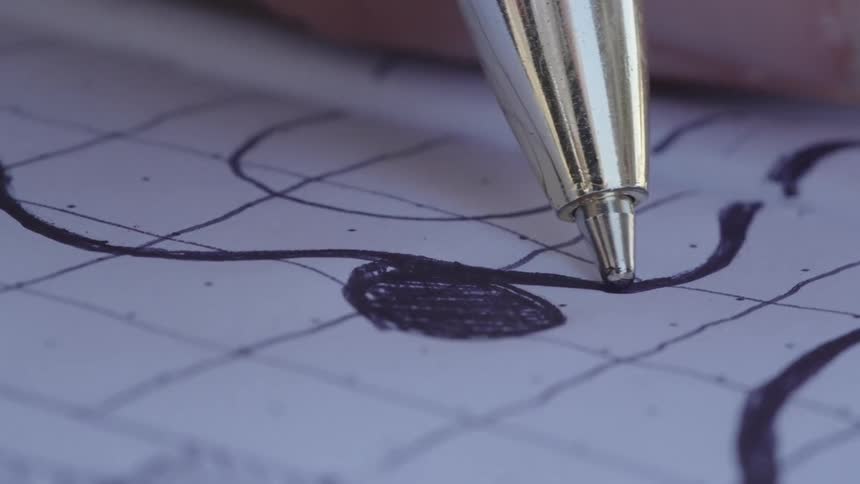 A pen writing a curved line on a piece of paper with a grid pattern
