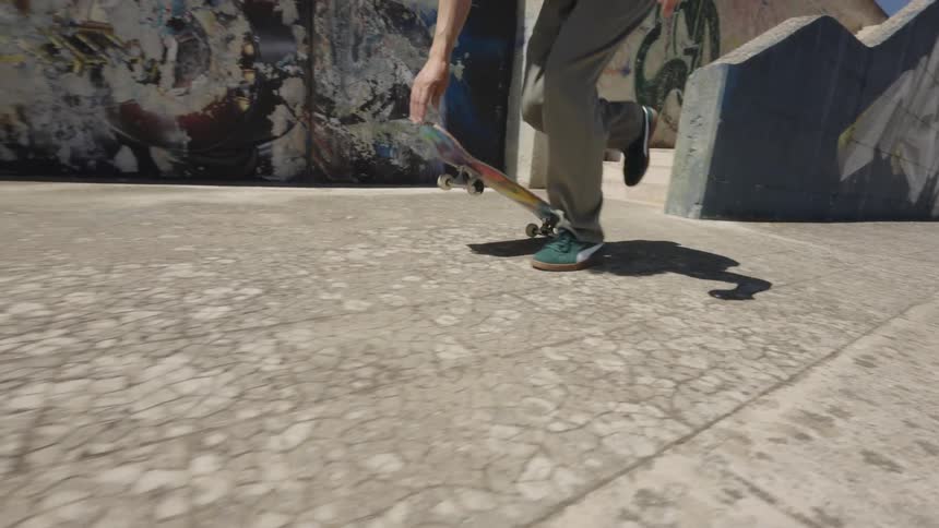A skateboarder skateboards in front of a vibrant graffiti wall showcasing skill and urban art