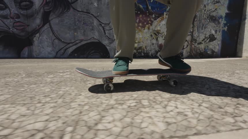 Legs of a person on a skateboard doing a flip maneuver