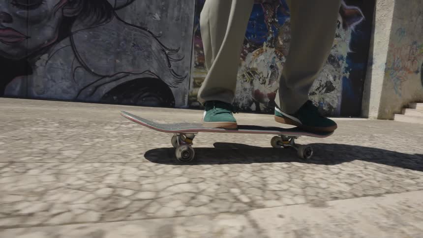A skateboarder on a stone sidewalk does a jump with the board