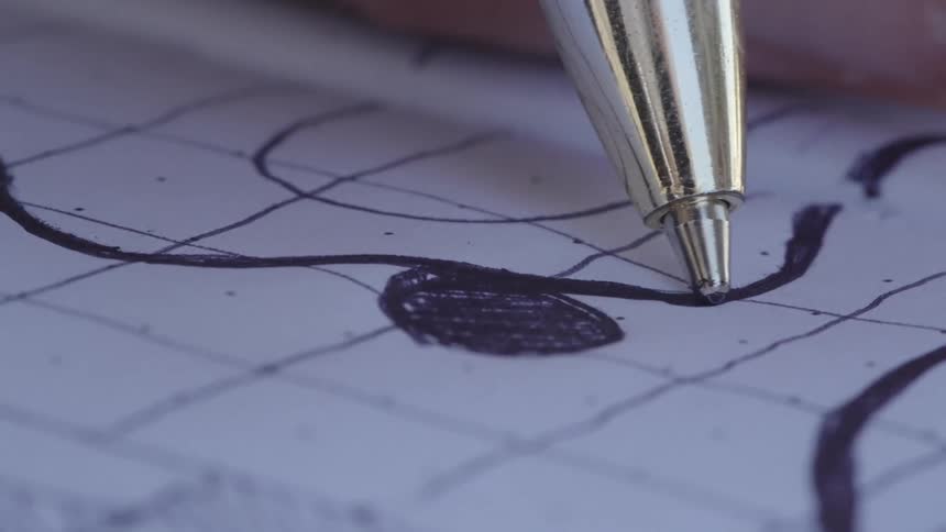 A pen writing a curved line on a piece of paper with a grid pattern