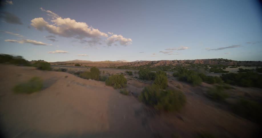 Aerial view of a paved highway in the middle of desert and low vegetation