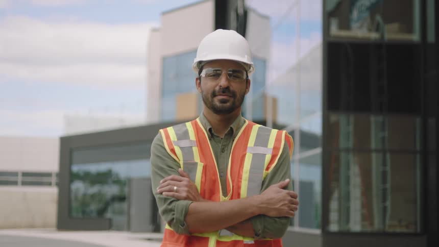 Man with a flared vest and a helmet crossing his arms