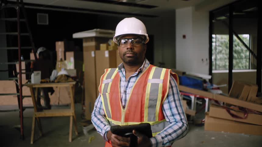 Man looks at a tablet in an interior construction site