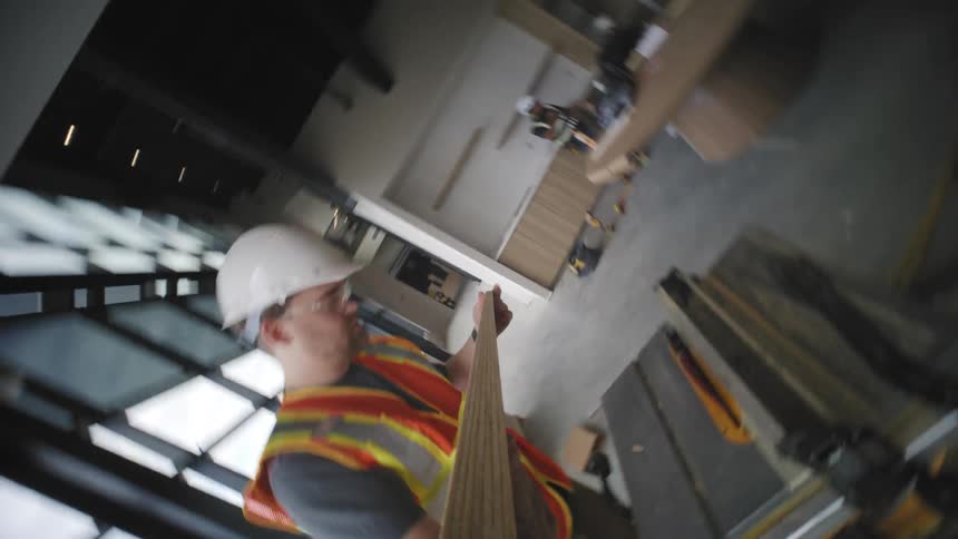 Point of view of a man checking a wooden slat on top of a machine