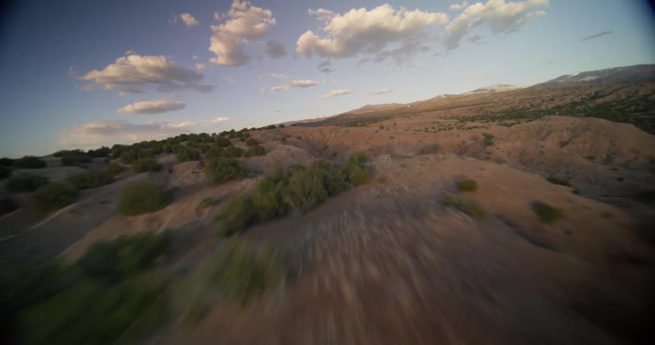 A vast desert landscape bathed in the warm glow of the setting sun