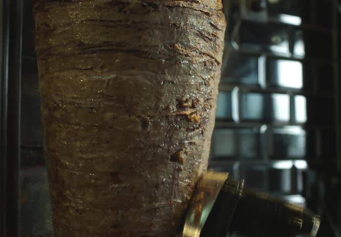 Cutting tool cutting fillets of meat being roasted in a restaurant