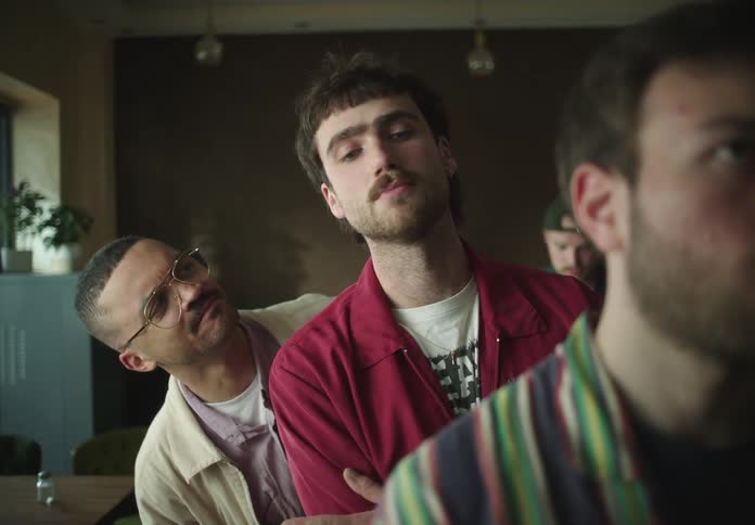 Men in a line watching the person in front
