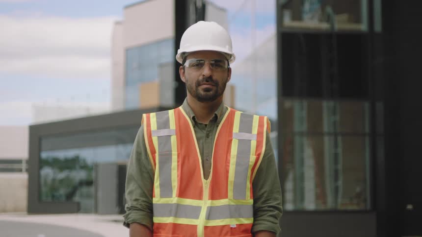 Man crossing his arms while wearing a protective helmet and a flared vest