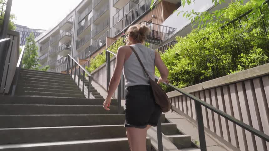 A woman climbs up the steps in the city