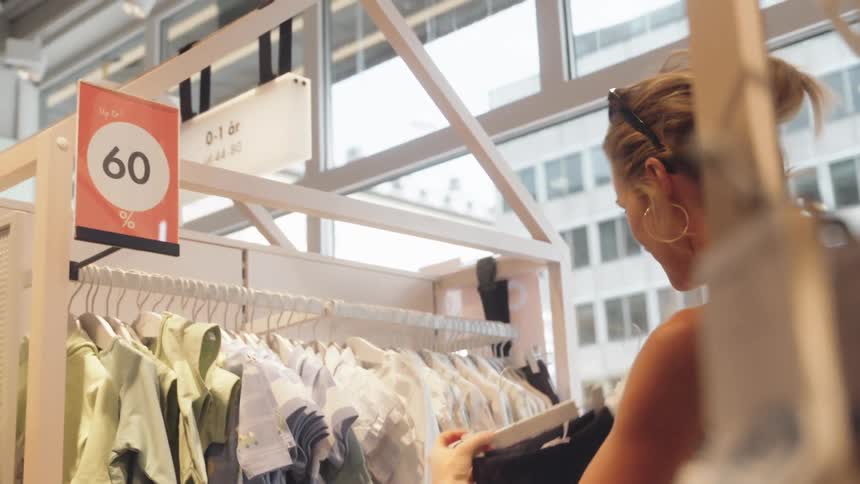 Woman looking at childrens clothes in a store