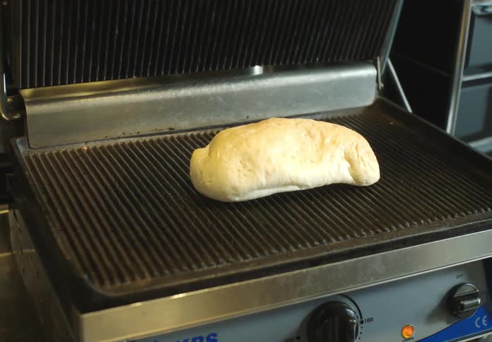 Hand placing a bread on a plate in a restaurant