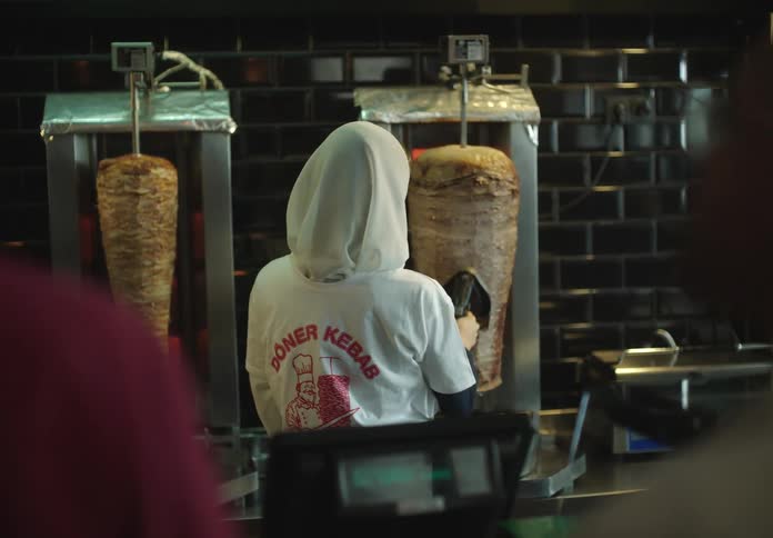 Woman cutting meat that is being grilled in a restaurant