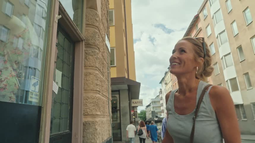 Smiling woman looking at a mural on a building