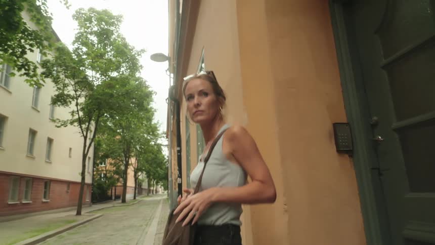 Woman walking out of a building door and down a cobblestone street