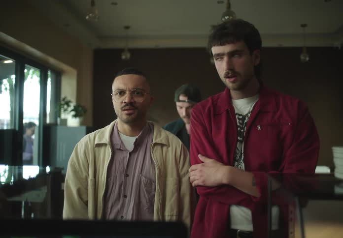 Two men looking at each other in a line indoors