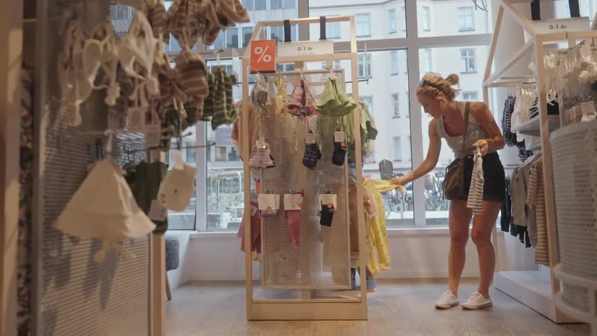Woman in a store in the childrens department looking at clothes