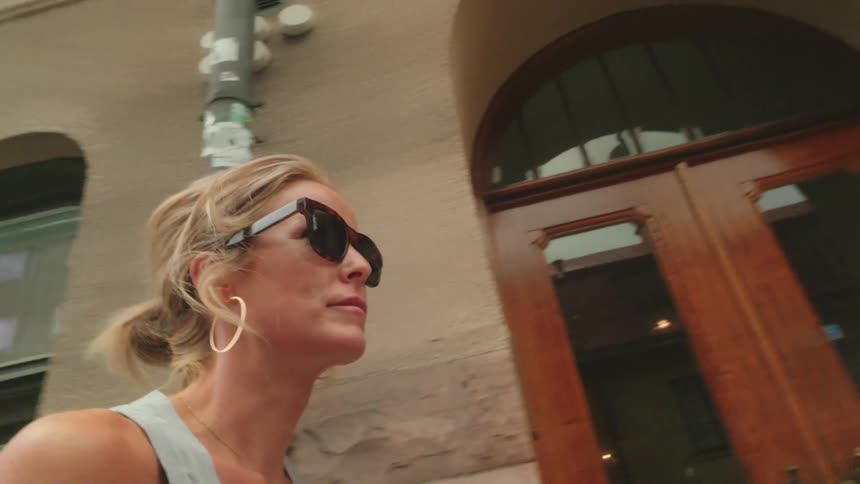 Woman walking through the city with sunglasses