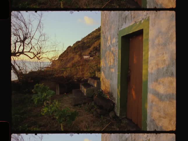 Wall and door of an abandoned house on a mountain by the sea