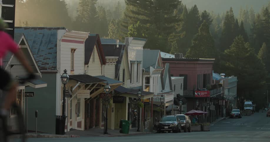 A quaint street lined with historic buildings in a small town with a pickup truck driving down the road