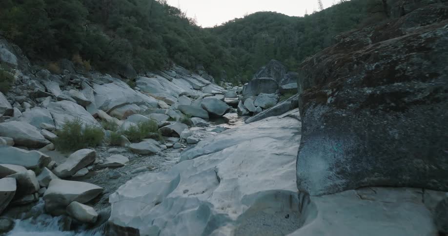 Landscape of a river in the middle of rocks with a bridge and mountains around