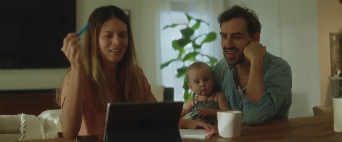 Happy couple with their child talk in the living room