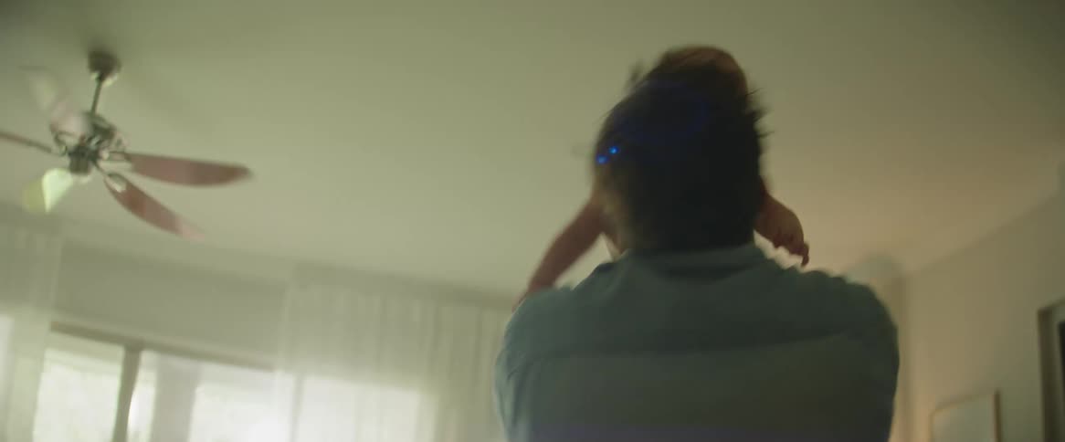 Mother watches spouse spin with their daughter at night